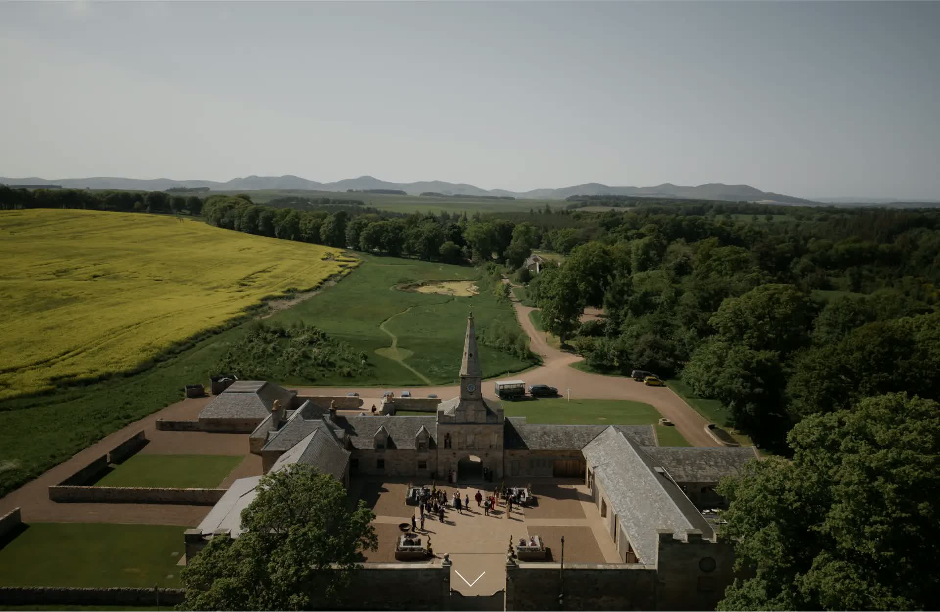 Rosebery Steading lit at dusk with the Midlothian hills beyond